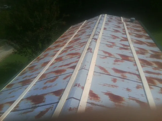 Rusted metal roof panels with new wood purlins before replacement — Storm Damage Roof Repair in Sanborn by Roofing Brothers