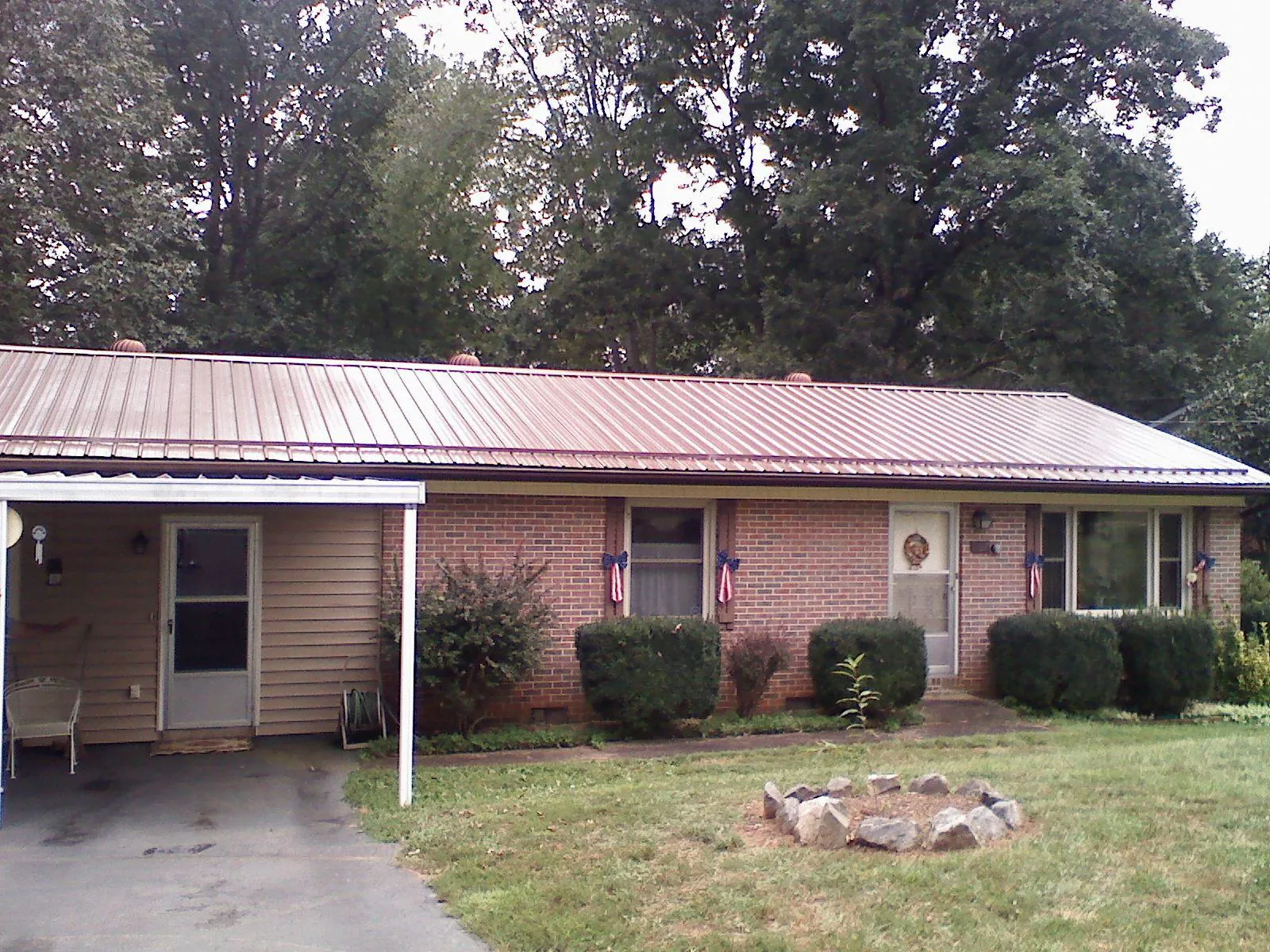 Bronze metal roof and carport on a brick ranch home — Roof Repair work by our crew in Sanborn